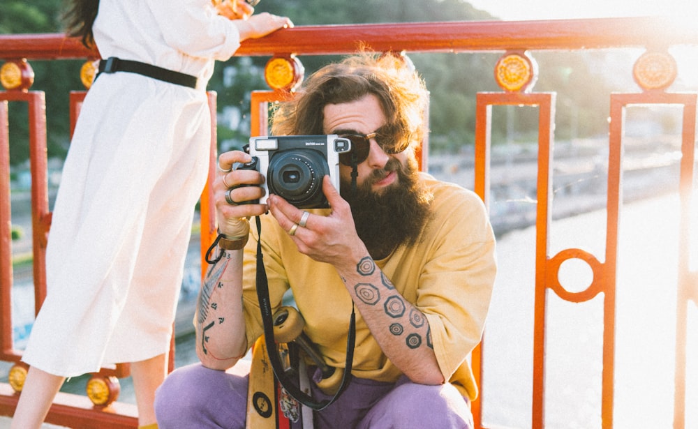 woman in purple shirt holding black camera