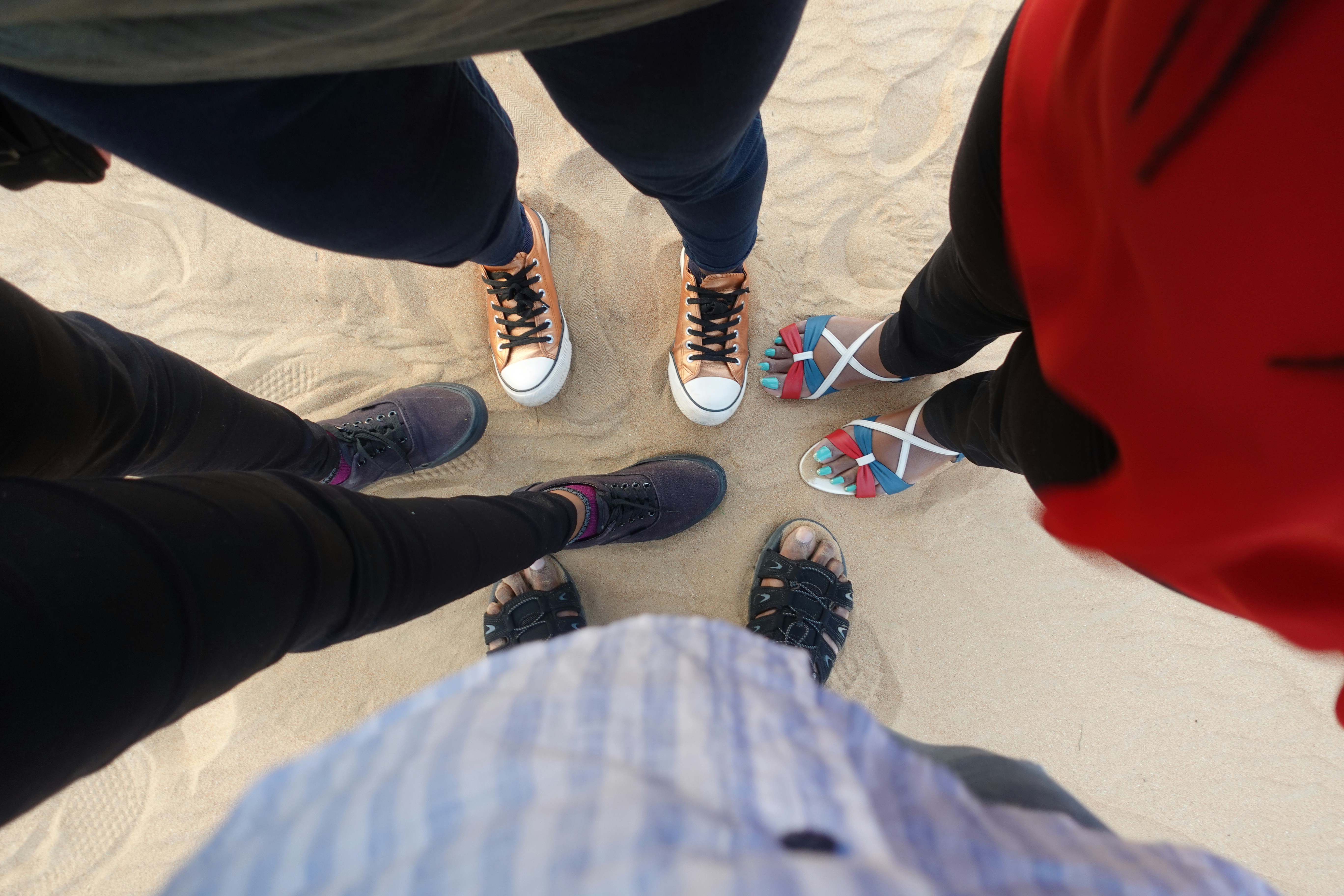 Person in schwarzen Hosen und schwarz-weißen Turnschuhen