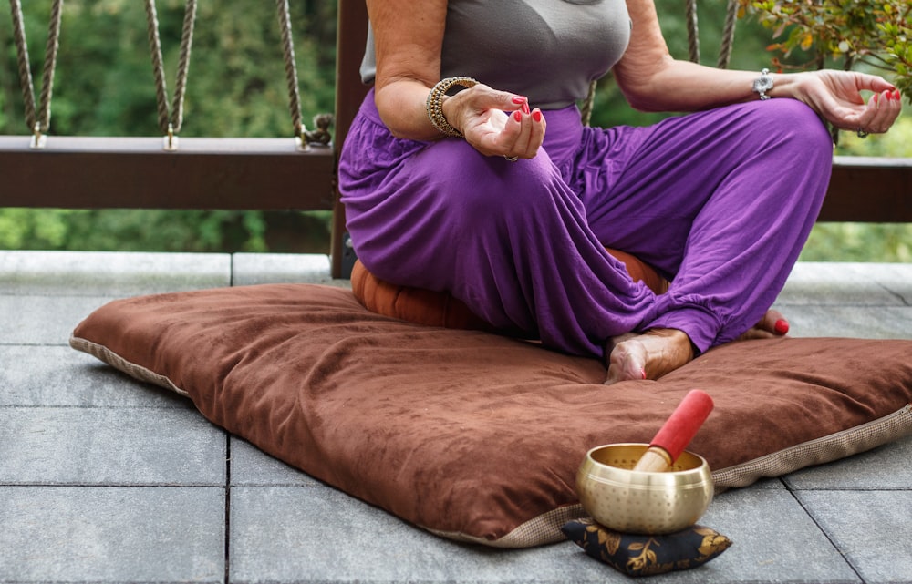 Frau im lila Kleid sitzt auf grauer Couch