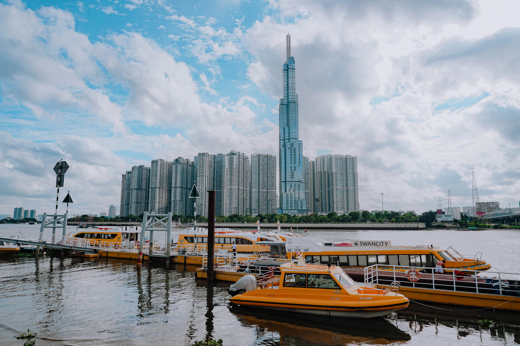 A passenger boat on the Sài Gòn River beneath Ho Chi Minh City's modern skyline