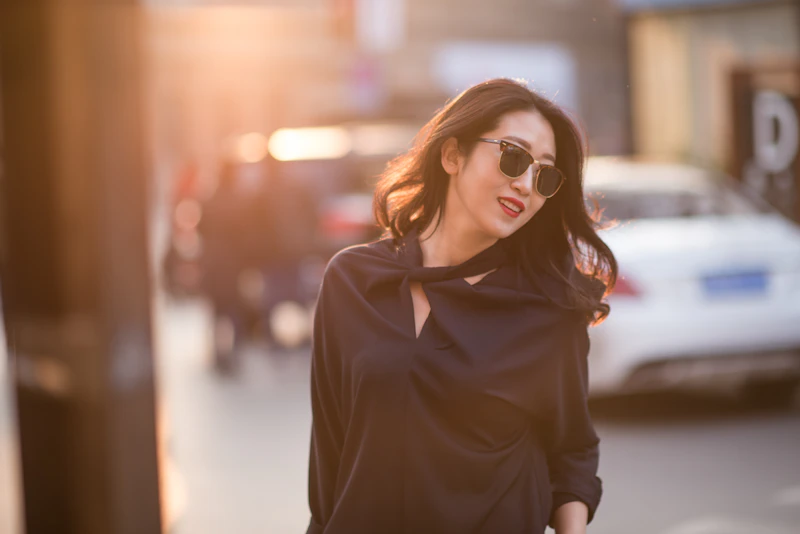 woman in black coat wearing brown sunglasses