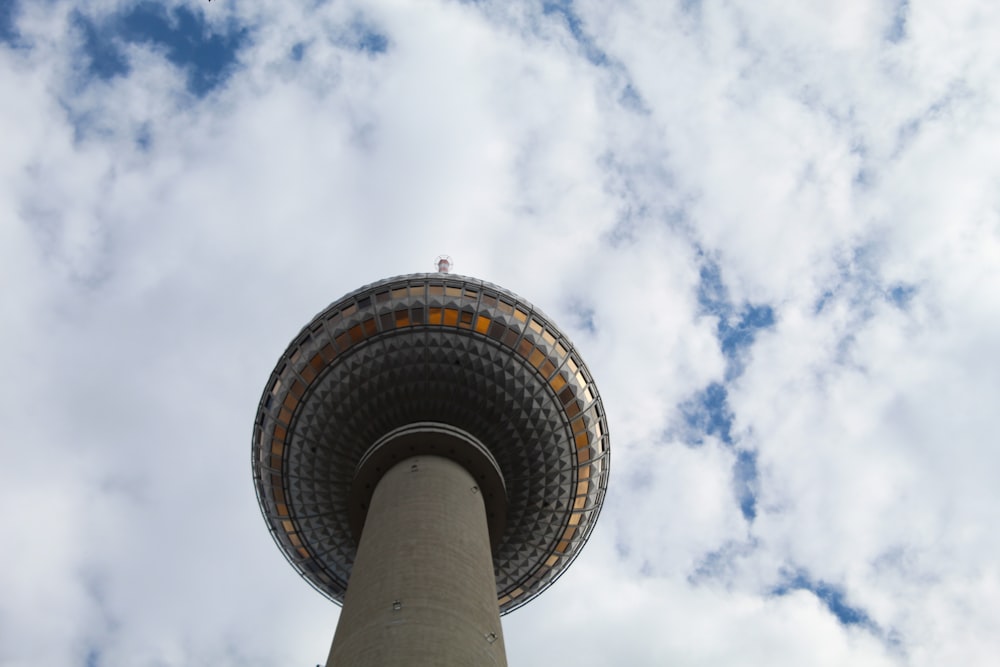 low angle photography of white and gray tower under white clouds and blue sky during daytime