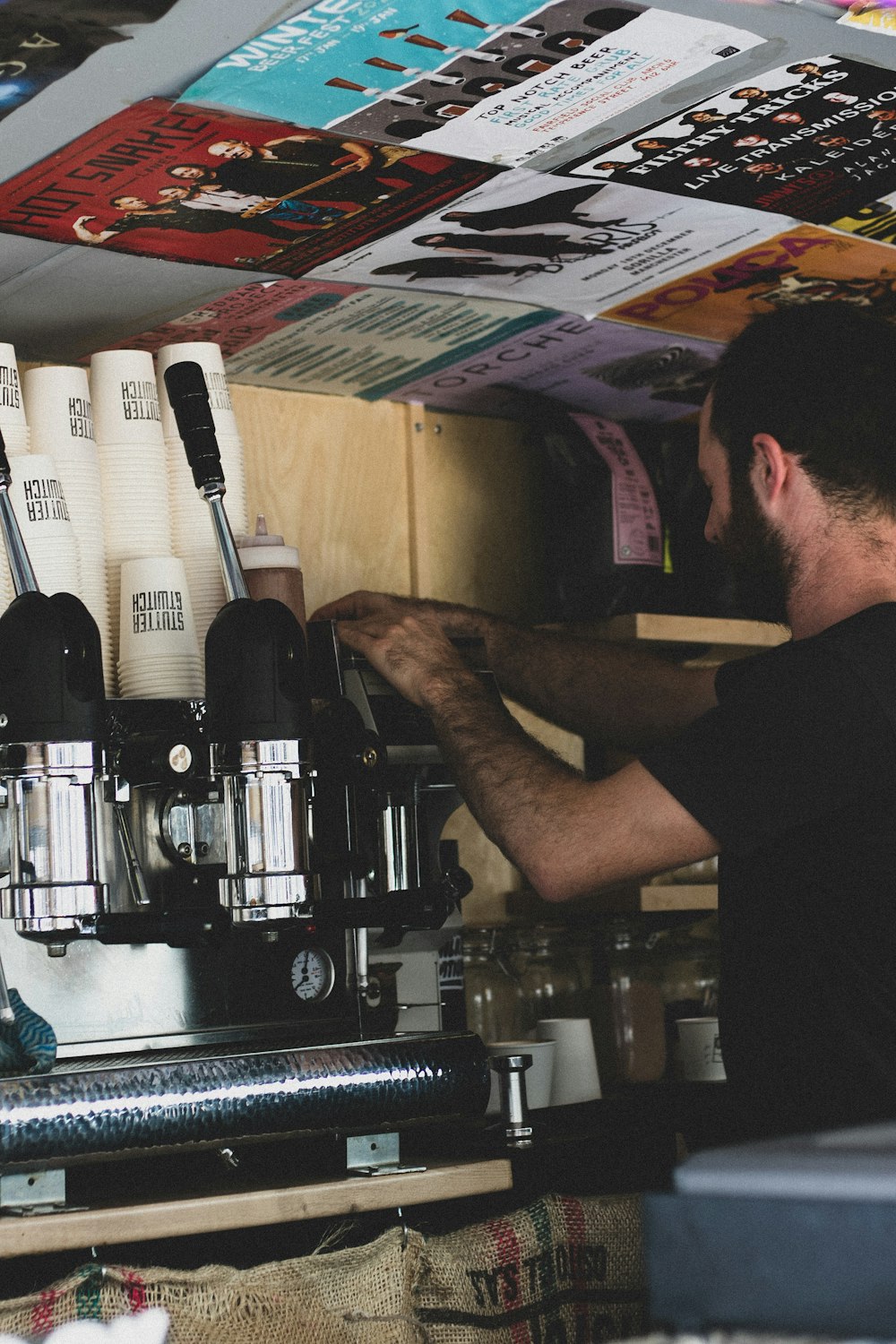 man in black t-shirt holding black and silver coffee maker