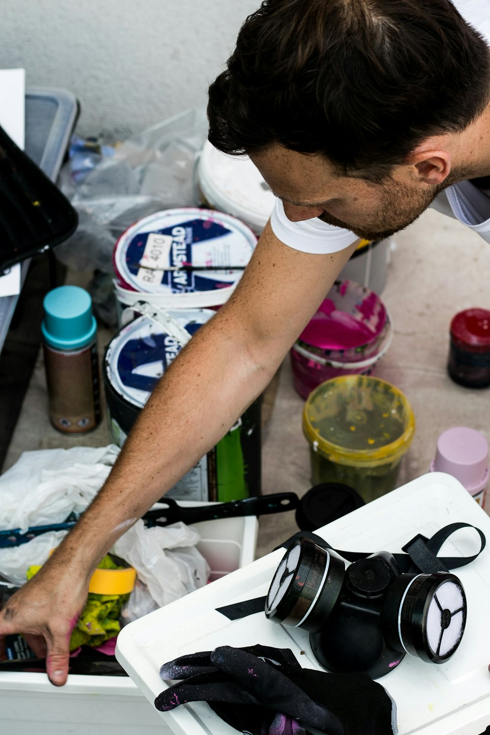 person in white t-shirt holding white plastic container