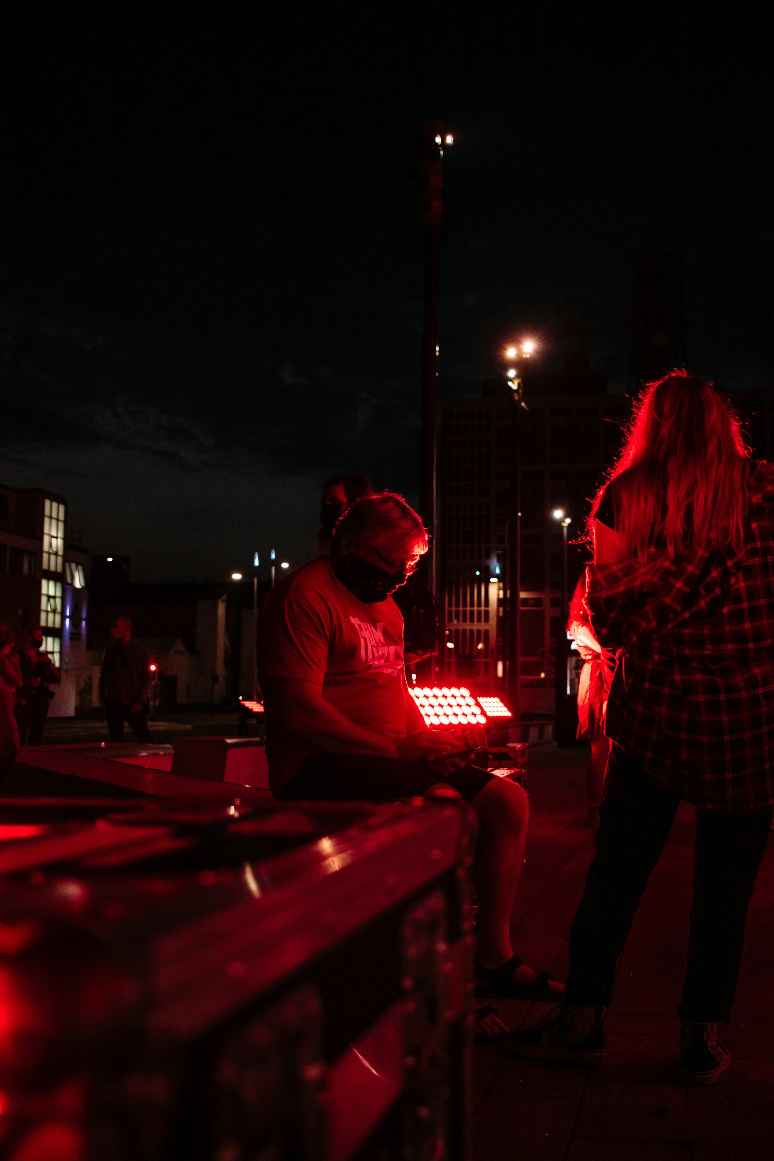 man and woman standing beside brown wooden table during night time