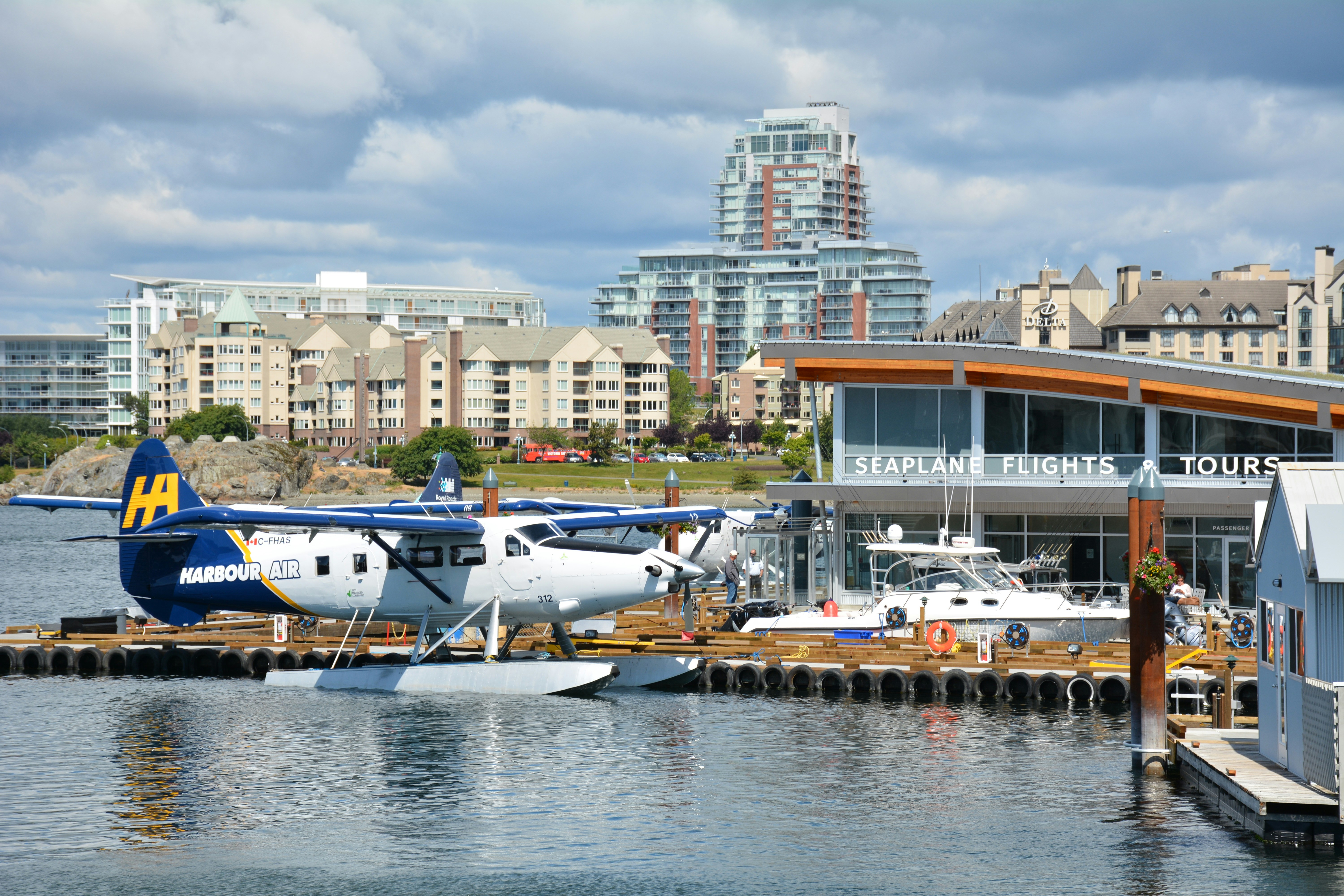 white and blue airplane on dock during daytime