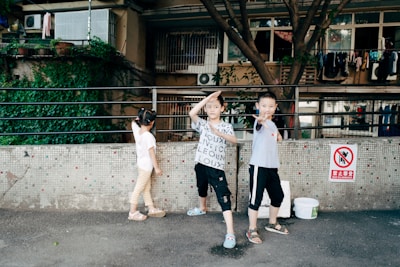 Children playing near a balcony with protective safety nets.