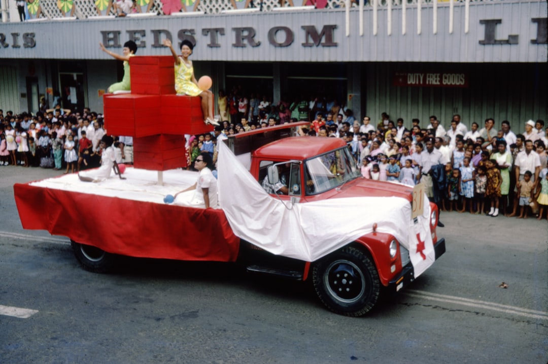 white and red vintage car on road