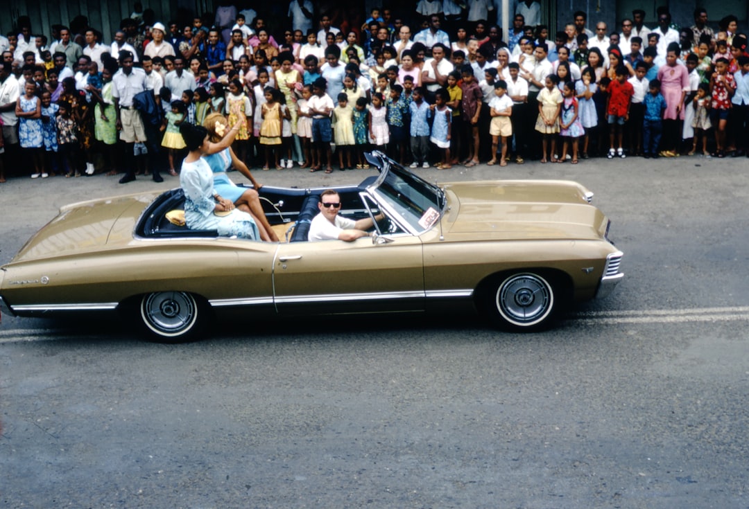 people riding on yellow convertible car during daytime