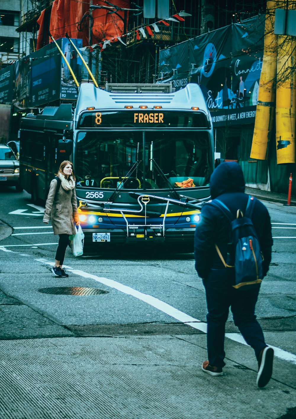 man in black jacket and blue denim jeans walking on pedestrian lane during daytime