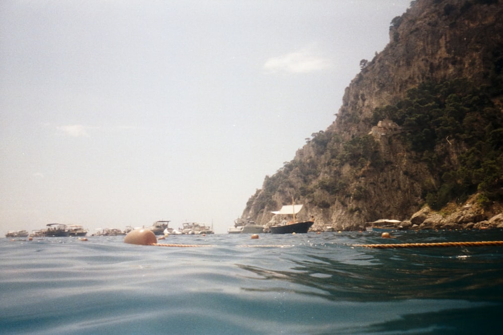 woman in body of water near brown rock formation during daytime