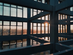 A sleek, modern Sydney home with clean lines and large glass windows glowing warmly at sunset.