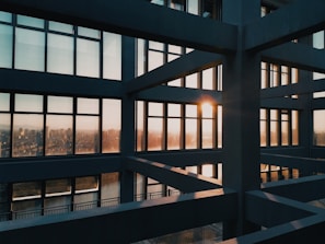Modern luxury container home with large glass windows and golden accents at sunset