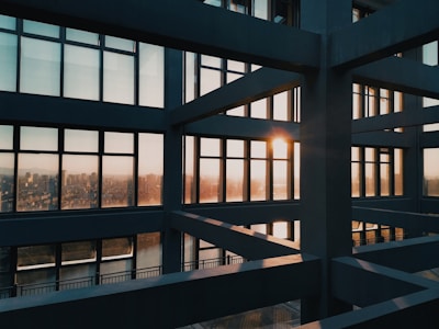A sleek, modern Sydney home with clean lines and large glass windows glowing warmly at sunset.