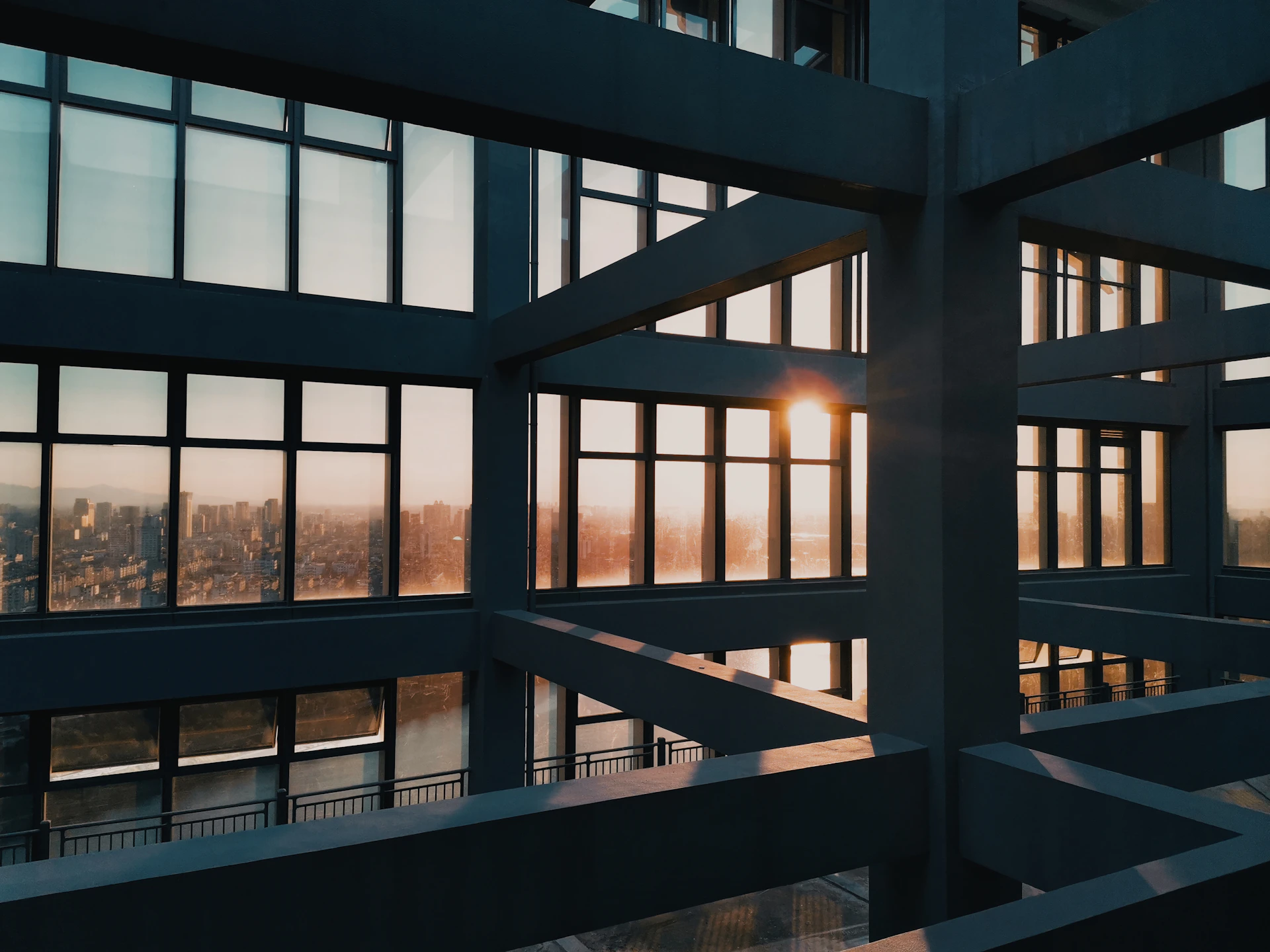 A sleek, cinematic frame from a luxury real estate video showcasing a modern glass-fronted home at sunset.