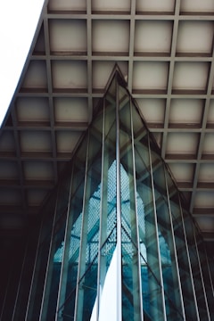 Geometric glass and metal structures with reflections create an abstract architectural pattern. The use of lines, grids, and angles highlights modern design, with a harmonious blend of symmetry and structure.