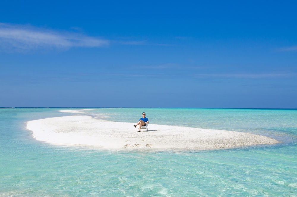 woman in blue dress walking on beach during daytime