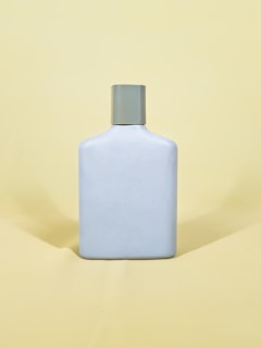 white and black bottle on yellow table