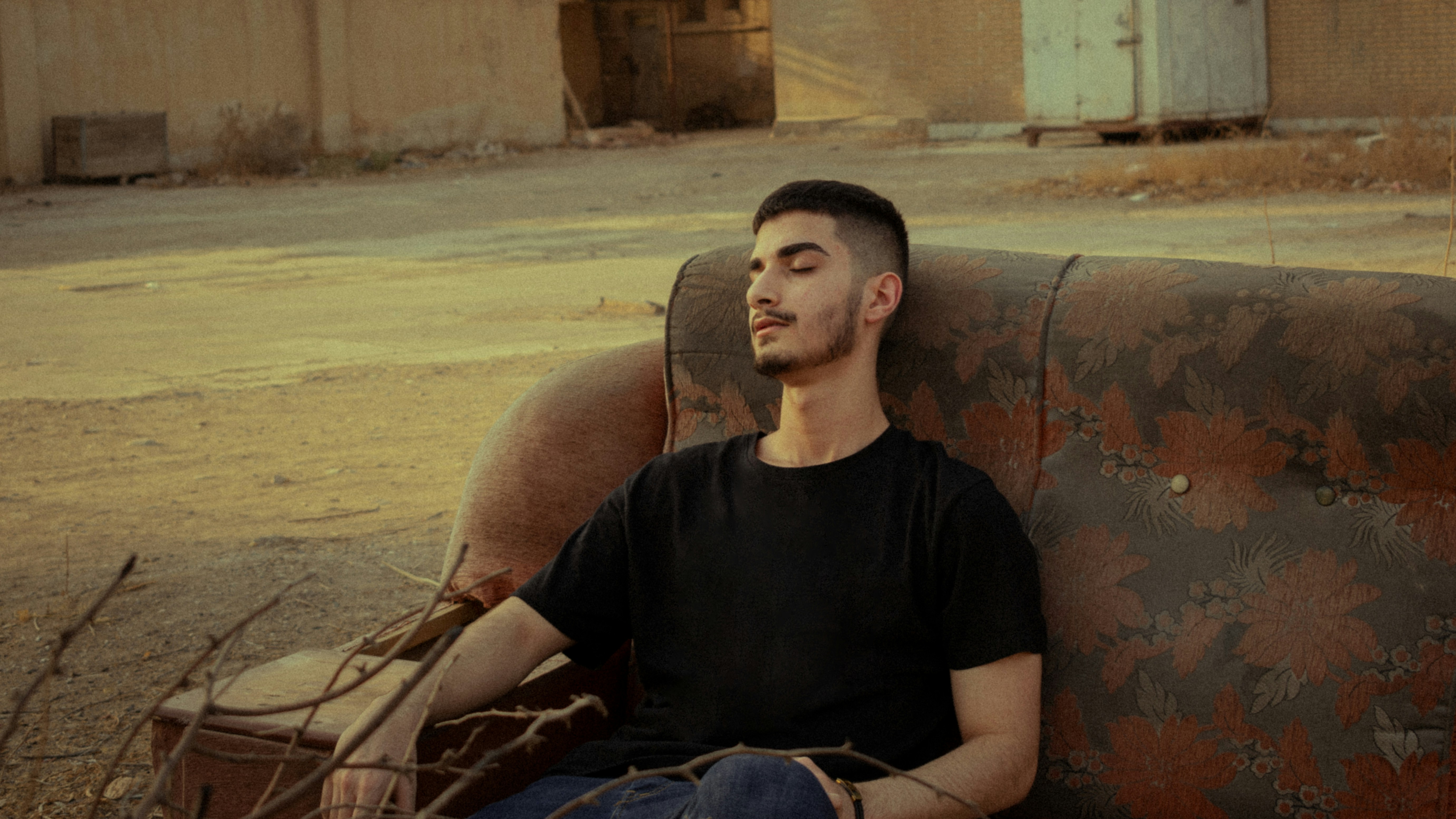 man in black crew neck t-shirt sitting on brown wooden bench