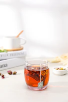 A peaceful scene of herbal infusions brewing in glass teapots on a cream-colored cloth.