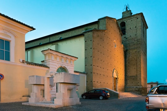 black car parked beside brown concrete building during daytime in Penne Italy