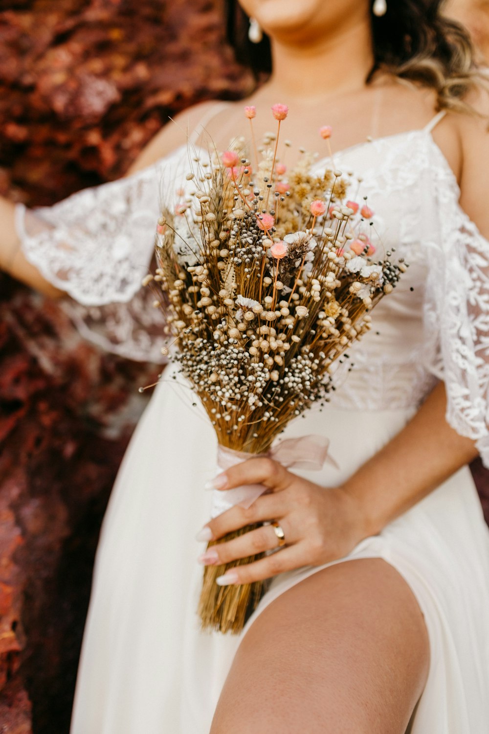 woman in white dress holding bouquet of flowers