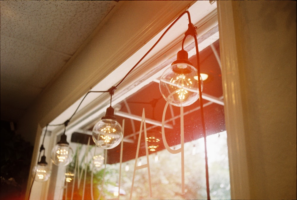 Lampe suspendue en verre transparent allumée près de la fenêtre