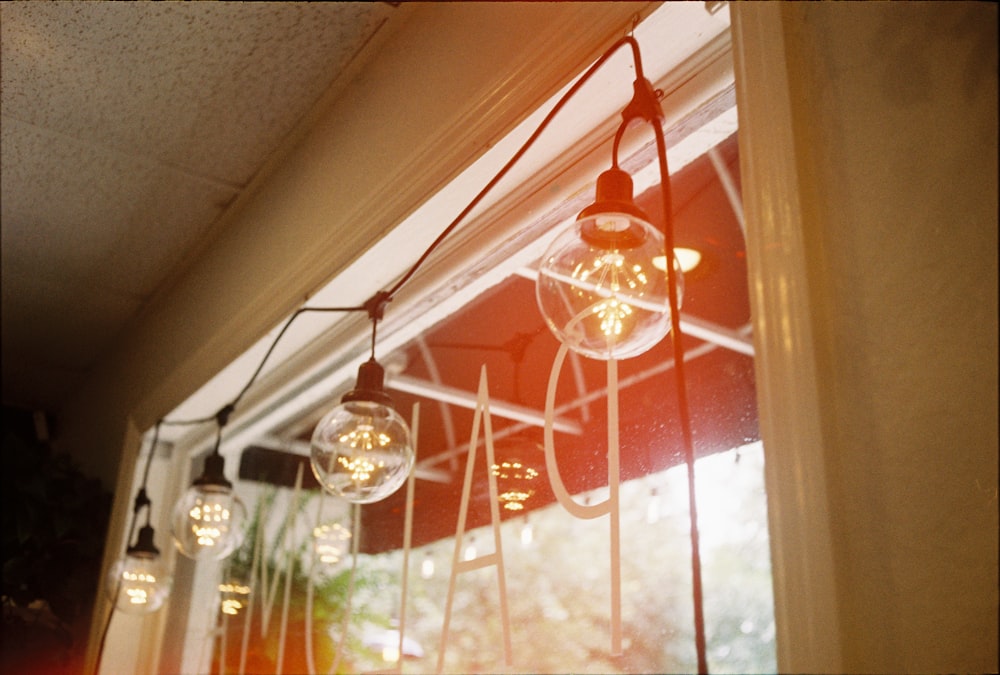 clear glass pendant lamp turned on near window