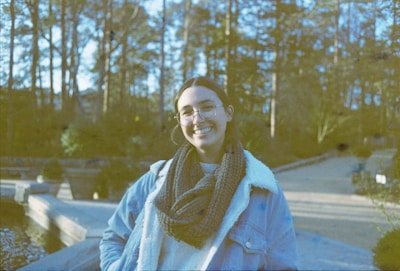 A model wearing a cozy scarf outdoors on a crisp day, smiling as the scarf gently catches the breeze.