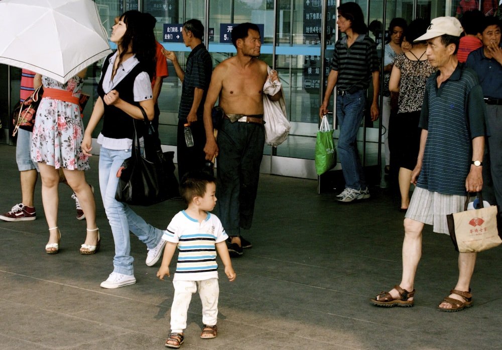 man in black shorts standing beside woman in white and black striped shirt