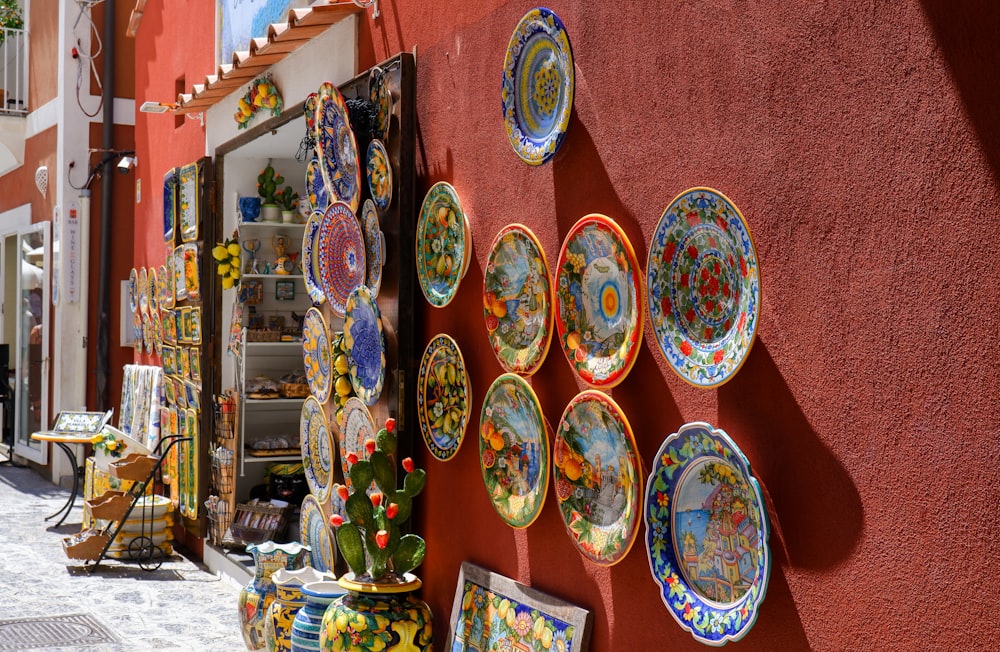 a red wall with a bunch of plates on it