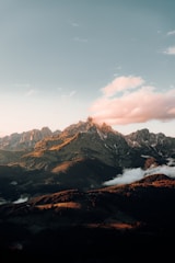 A scenic airplane flying over a mountain range during sunset.