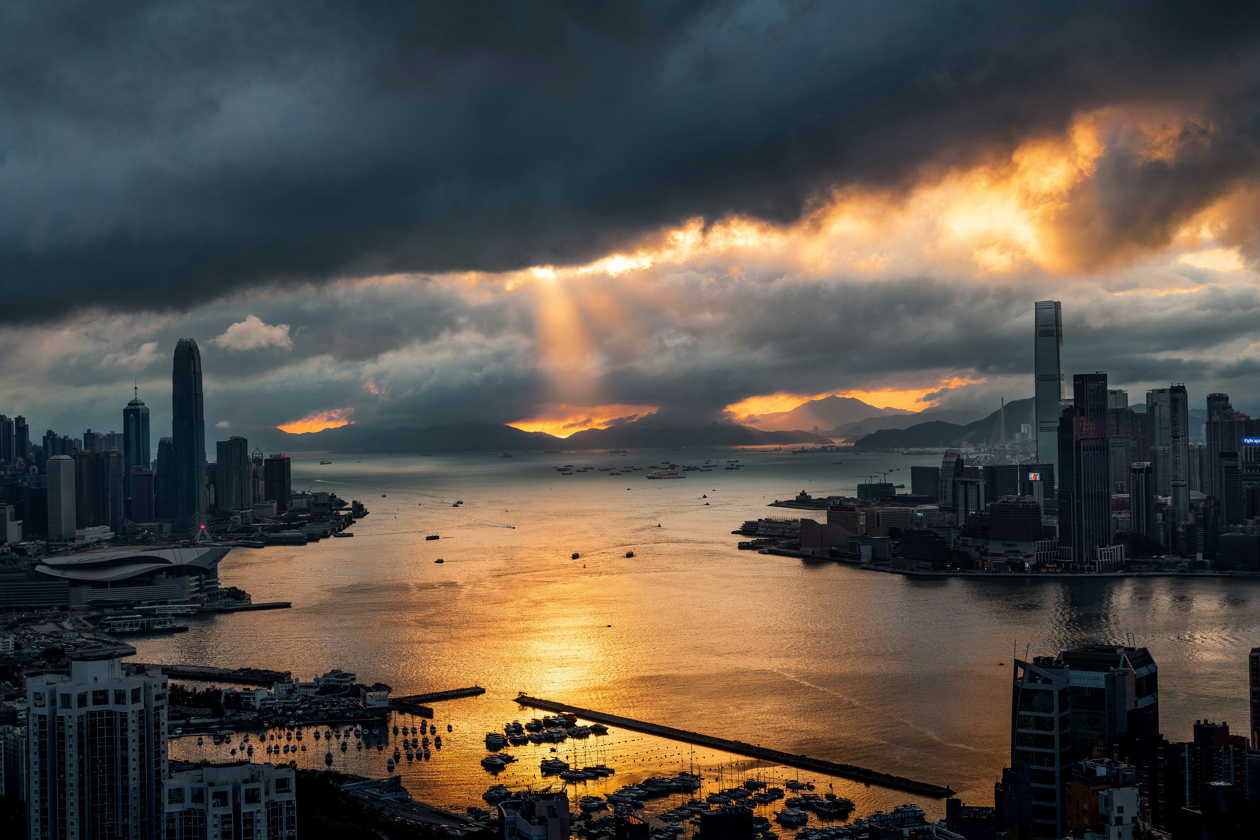 city skyline near body of water during sunset