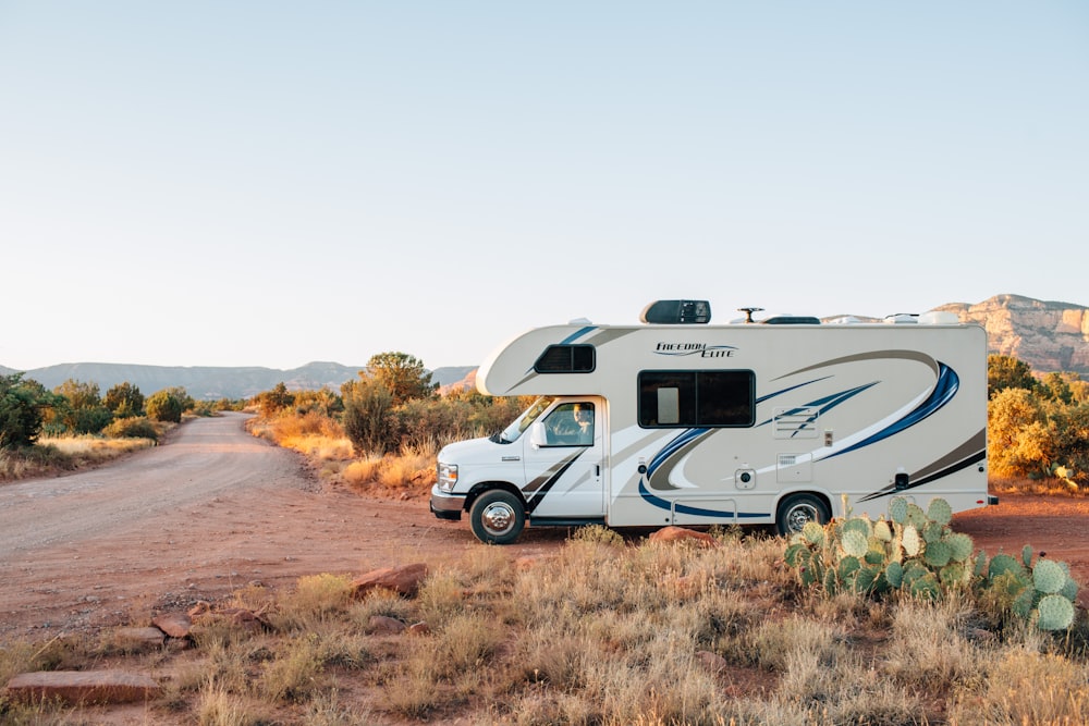 white and brown rv on brown grass field during daytime