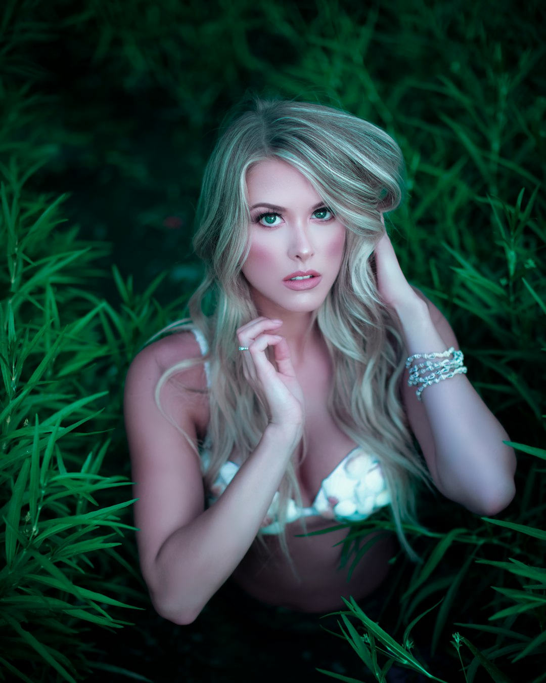 woman in white tank top sitting on green grass field