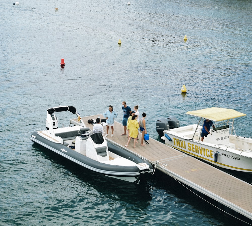 personnes sur un bateau blanc et noir sur la mer pendant la journée