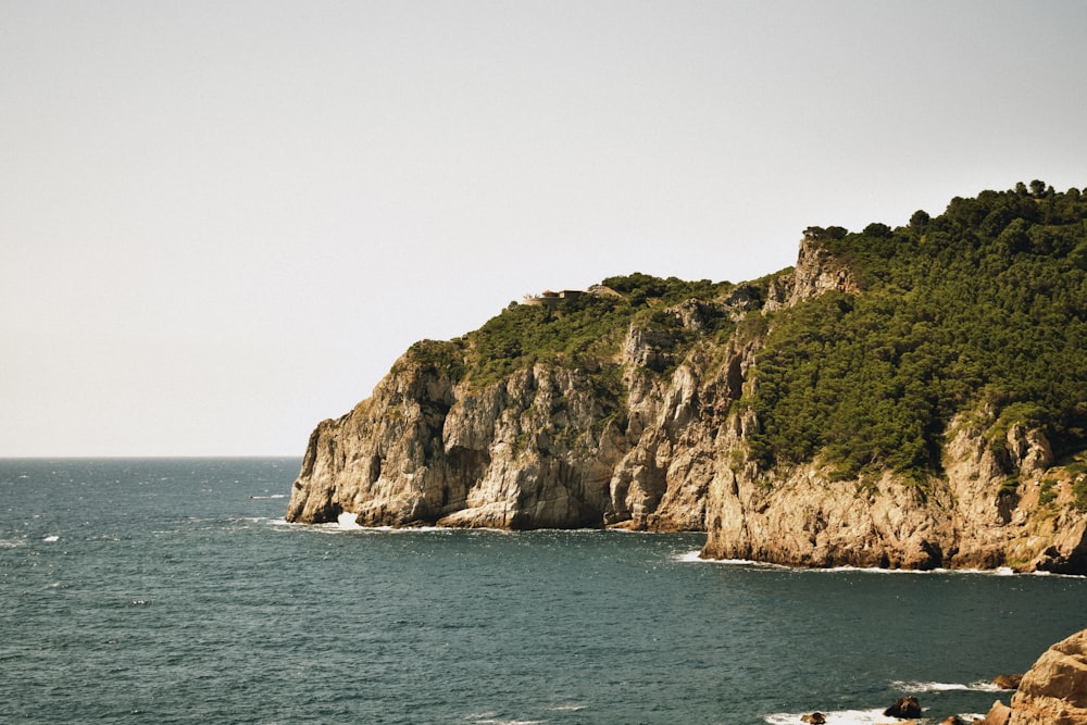 a large body of water next to a rocky cliff