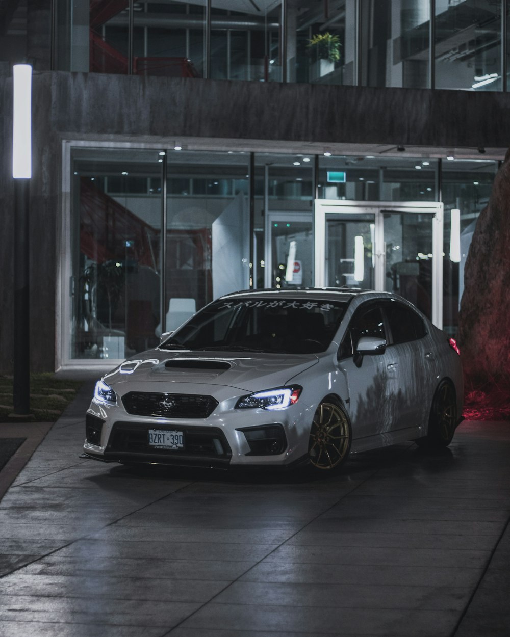 silver bmw m 3 coupe parked in front of glass building