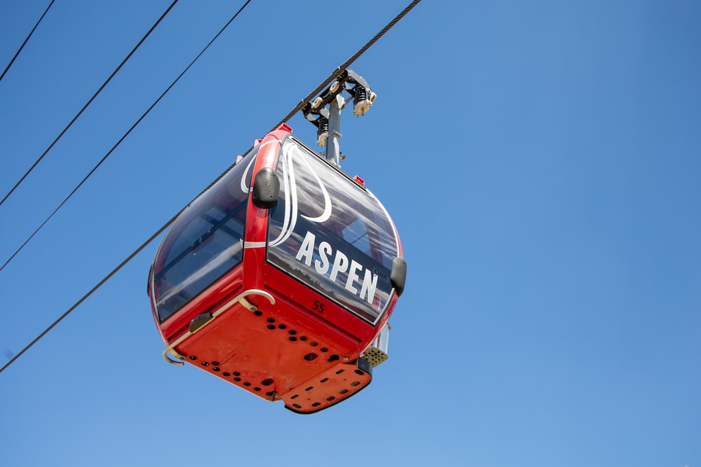 Teleférico rojo y blanco bajo el cielo azul durante el día