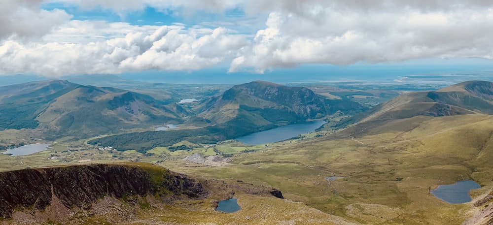 green and brown mountains under white clouds and blue sky during daytime