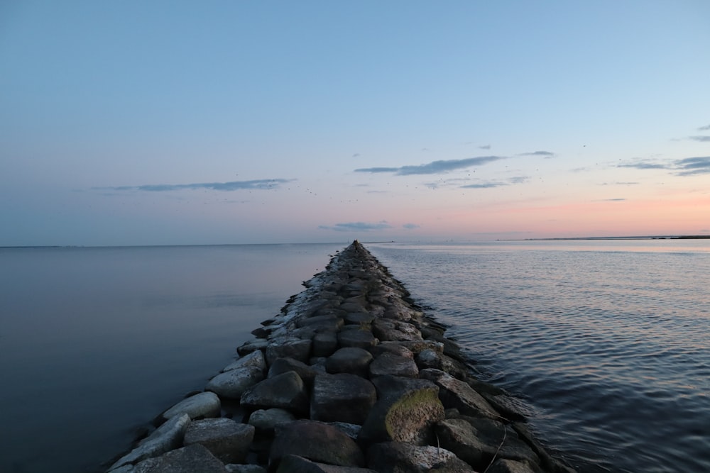 gray rocks near body of water during daytime