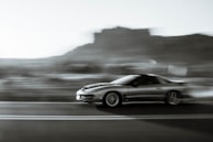 A sporty coupe captured in motion on the road.