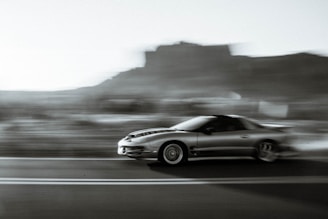 A sporty coupe captured in motion on the road.