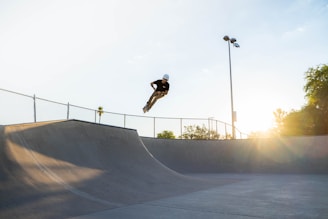 man in black jacket and black pants riding on black skateboard during daytime