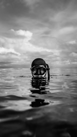 grayscale photo of person wearing goggles on water