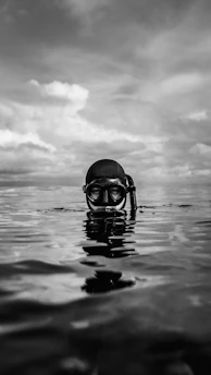 grayscale photo of person wearing goggles on water