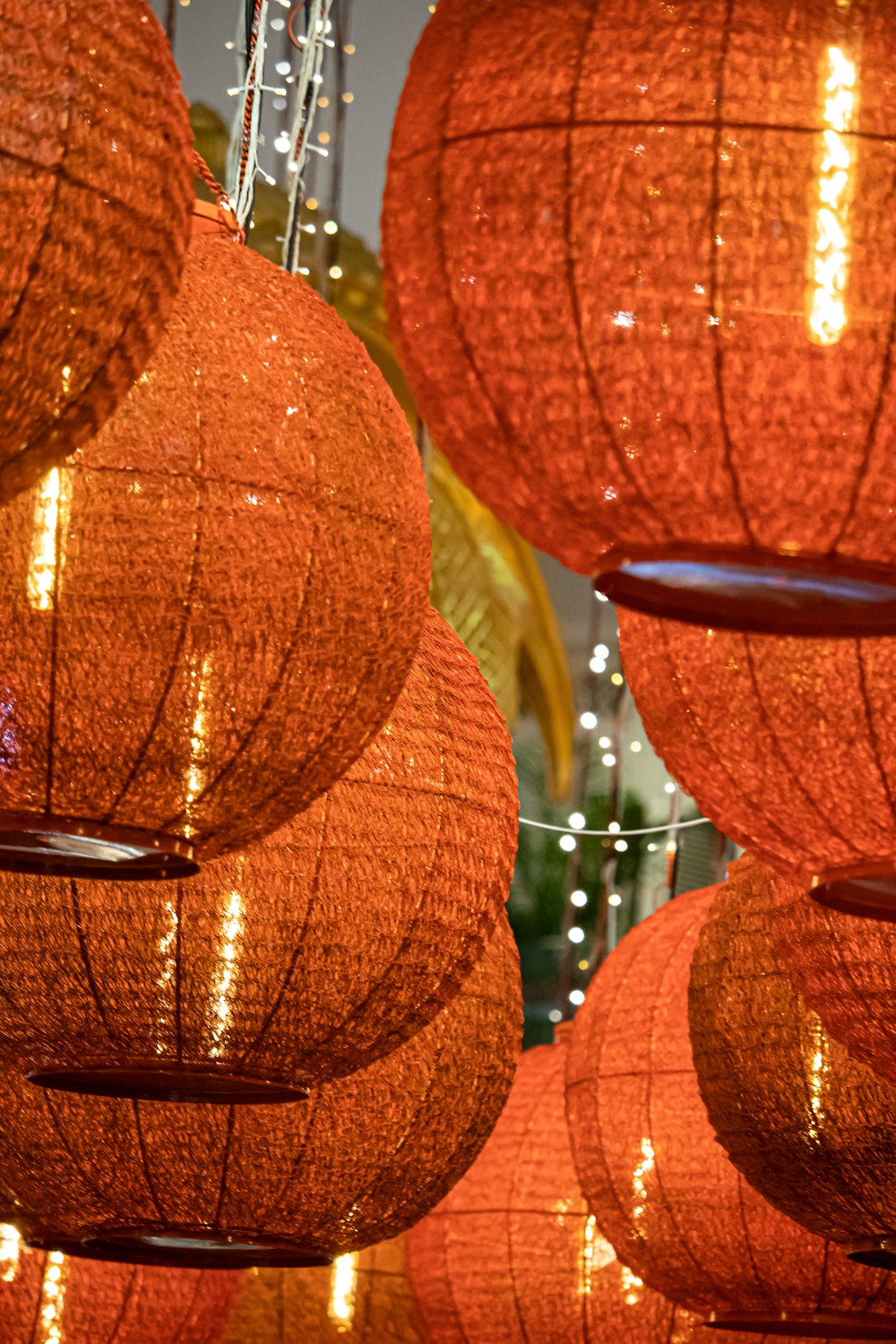 a group of orange lanterns hanging from a ceiling