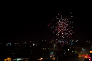 Colorful fireworks exploding in the night sky over a cityscape.