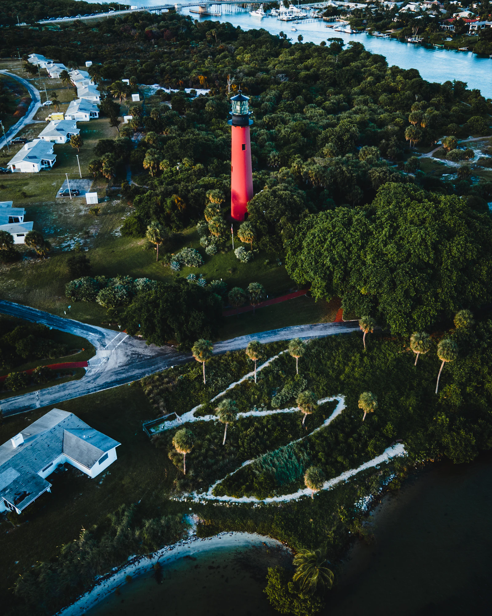 Aerial view of the red Jupiter Inlet Lighthouse surrounded by trees, Florida