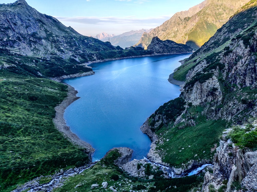 lake in the middle of mountains during daytime